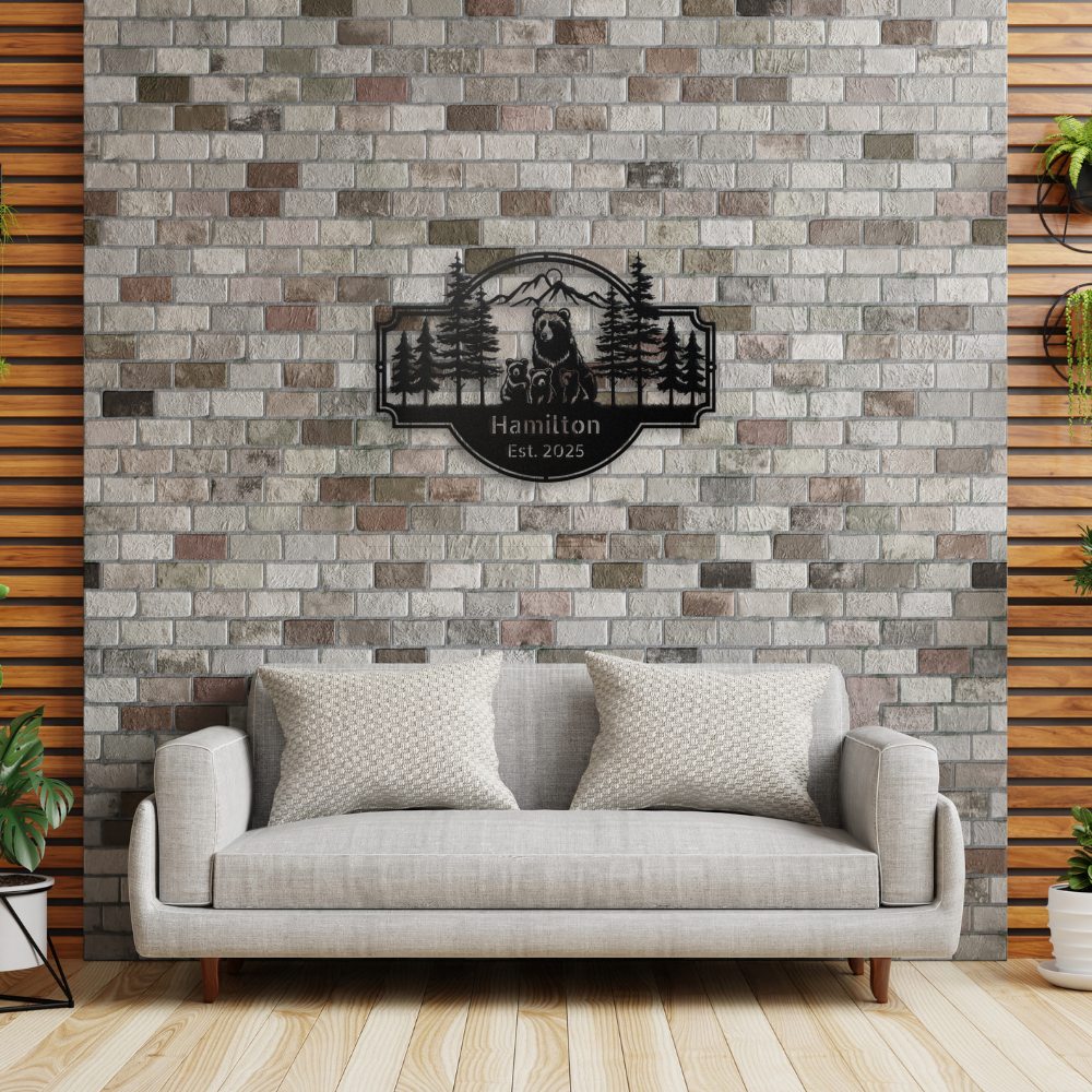 Personalized Bear Family Metal Sign – Custom Cabin & Family Name Wall Art in black against a brick feature wall in a contempory living room, with a tan sofa beneath the sign.
